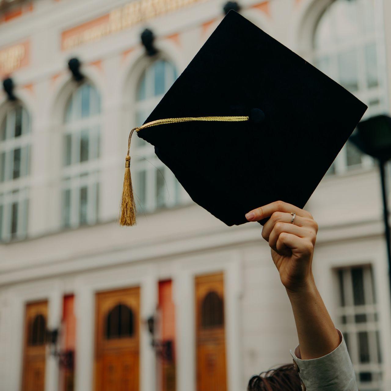 person holding black academic hat